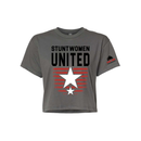 Stuntwomen United dark grey women’s cropped T-shirt shown from the front, featuring bold STUNTWOMEN UNITED text with distressed red stripe star graphic and Stunt Team sleeve logo.