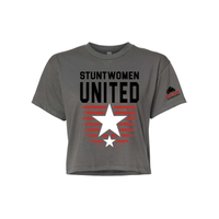 Stuntwomen United dark grey women’s cropped T-shirt shown from the front, featuring bold STUNTWOMEN UNITED text with distressed red stripe star graphic and Stunt Team sleeve logo.
