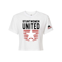 Stuntwomen United white women’s cropped T-shirt shown from the front, featuring bold STUNTWOMEN UNITED text with distressed red stripe star graphic and Stunt Team sleeve logo.