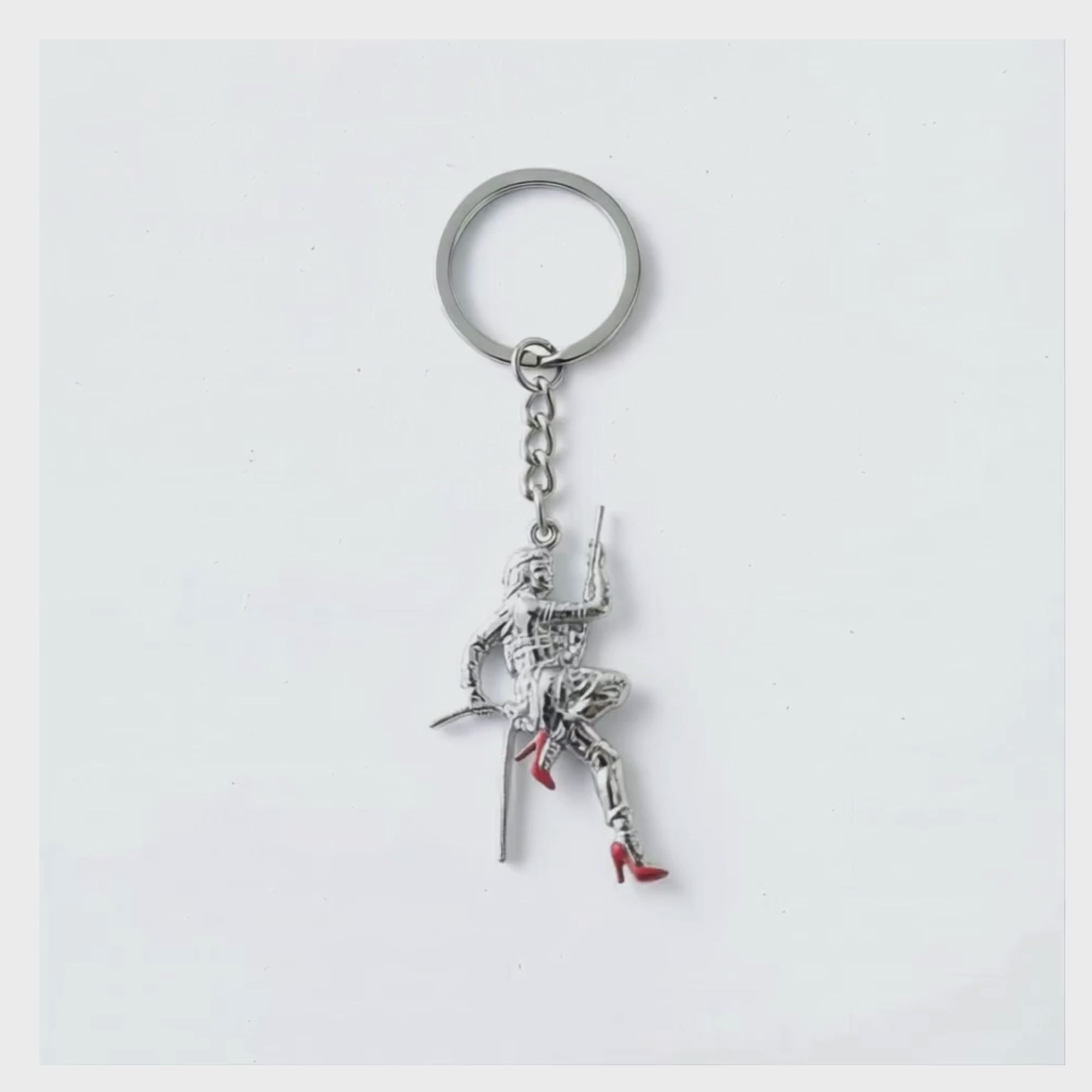 Video showing the Stuntwomen United metal keychain with a stuntwoman rappelling figure in red heels.